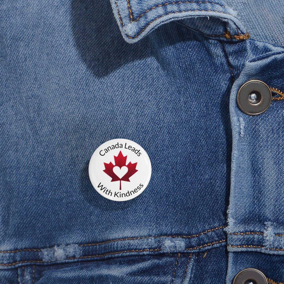 Button on a denim jacket with 'Canada Leads With Kindness' logo