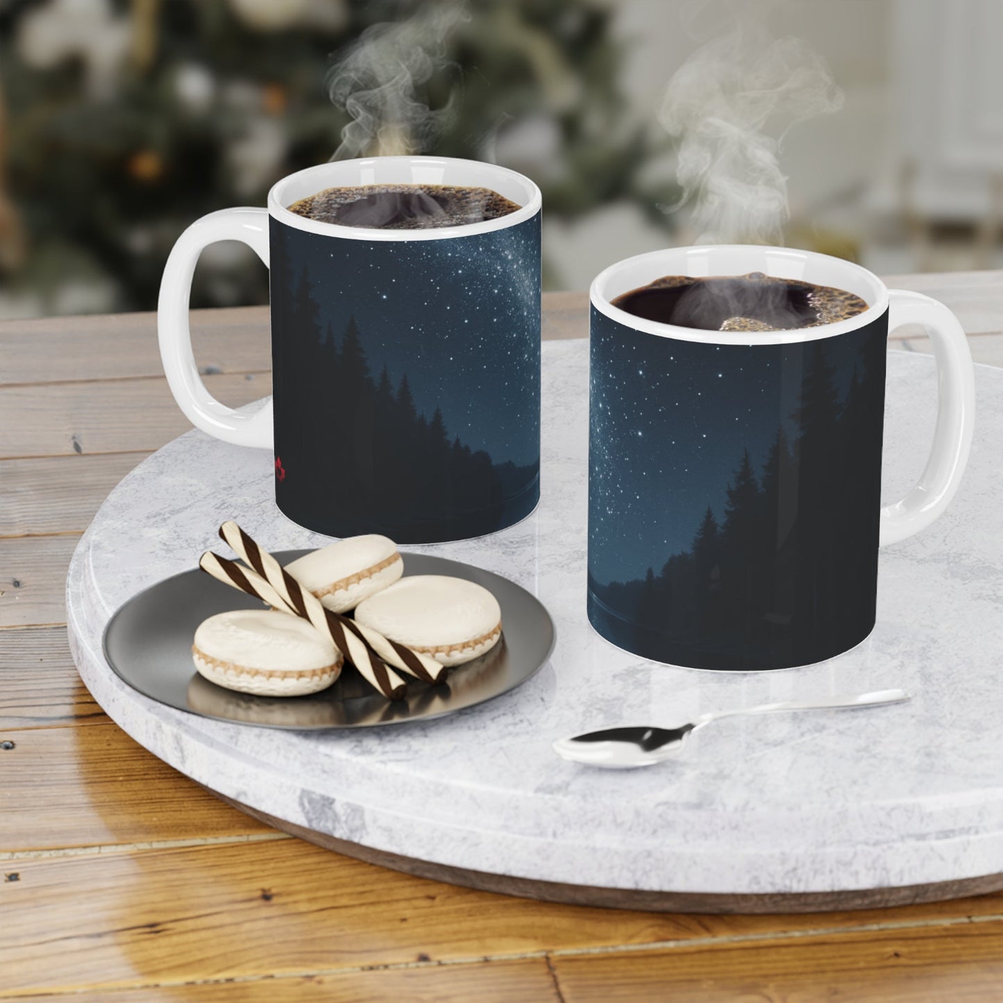 Two mugs with starry night design on a marble tray with cookies and a spoon.