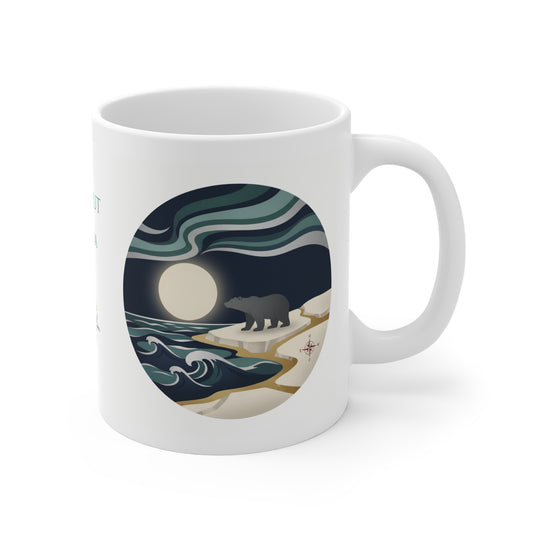 A white ceramic mug with a circular graphic print of a bear on a rocky shore under a full moon and swirling teal and navy waves, shown on a clean white background.