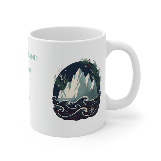 A white ceramic mug with a handle, featuring a circular graphic illustration of a snowy mountain peak surrounded by dark blue waves and green foliage, with partial teal text visible on the side.