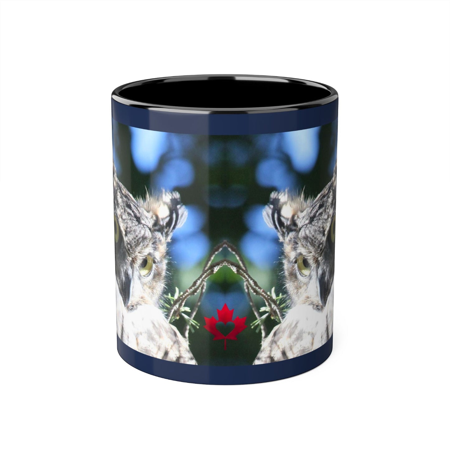 A ceramic mug with a dark navy blue rim and interior, featuring a wrap-around graphic of a mirrored owl design with a small red maple leaf at the centre