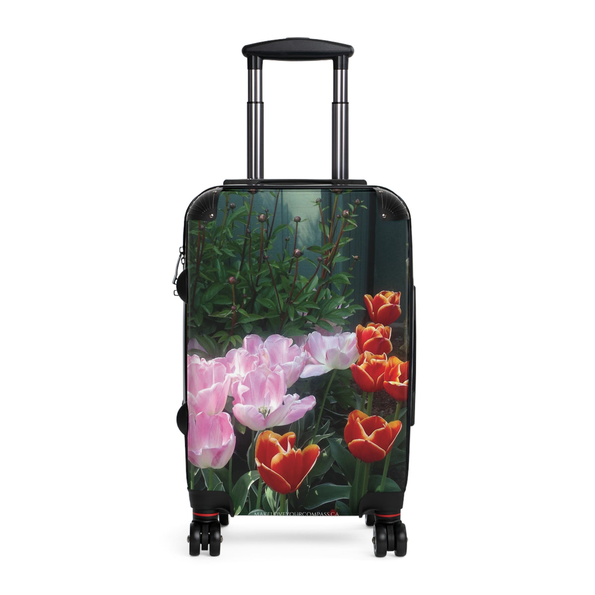 A hard-shell rolling suitcase with an extended black telescoping handle and four spinner wheels, featuring a printed floral design of pink tulips and red-orange tulips on a dark green background.