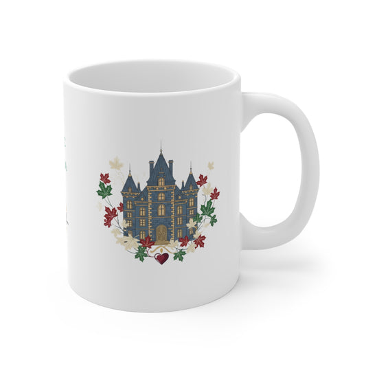 A white ceramic mug featuring a printed graphic of a blue castle surrounded by red and green leaves and white flowers, shown on a clean white background.