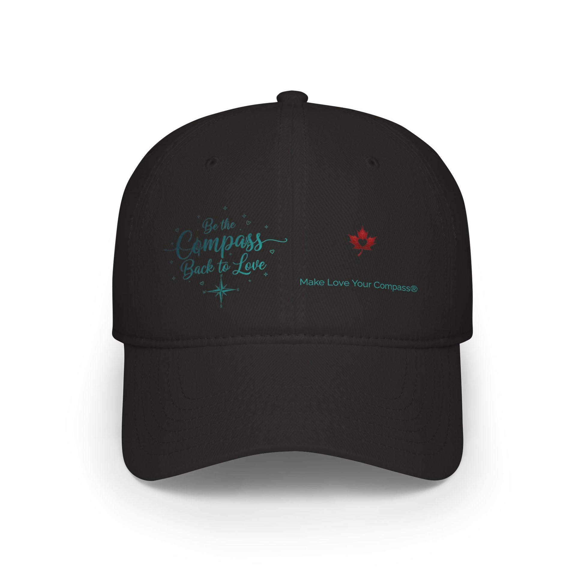A black baseball cap with embroidered text on the front. The left side features teal embroidery reading 'Be the Compass Back to Love' with a small compass star, and the right side features a small red maple leaf above the text 'Make Love Your Compass'.
