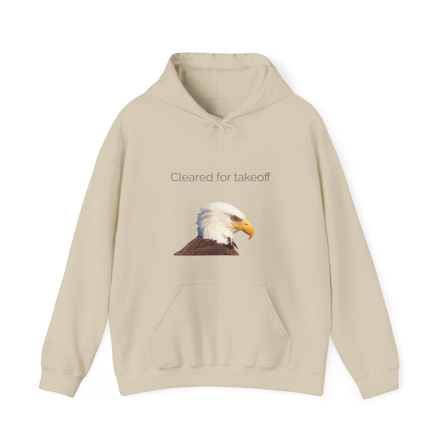 A beige pullover hoodie with a graphic of a bald eagle's head and the text 'Cleared for takeoff' printed on the chest, displayed against a solid white background.