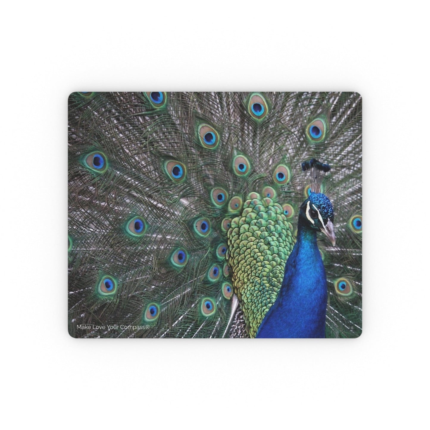A rectangular mouse pad with rounded corners featuring a detailed photographic print of a peacock with its tail feathers fanned out. The peacock has vibrant blue and green neck feathers with brown, black, and blue patterned feathers.
