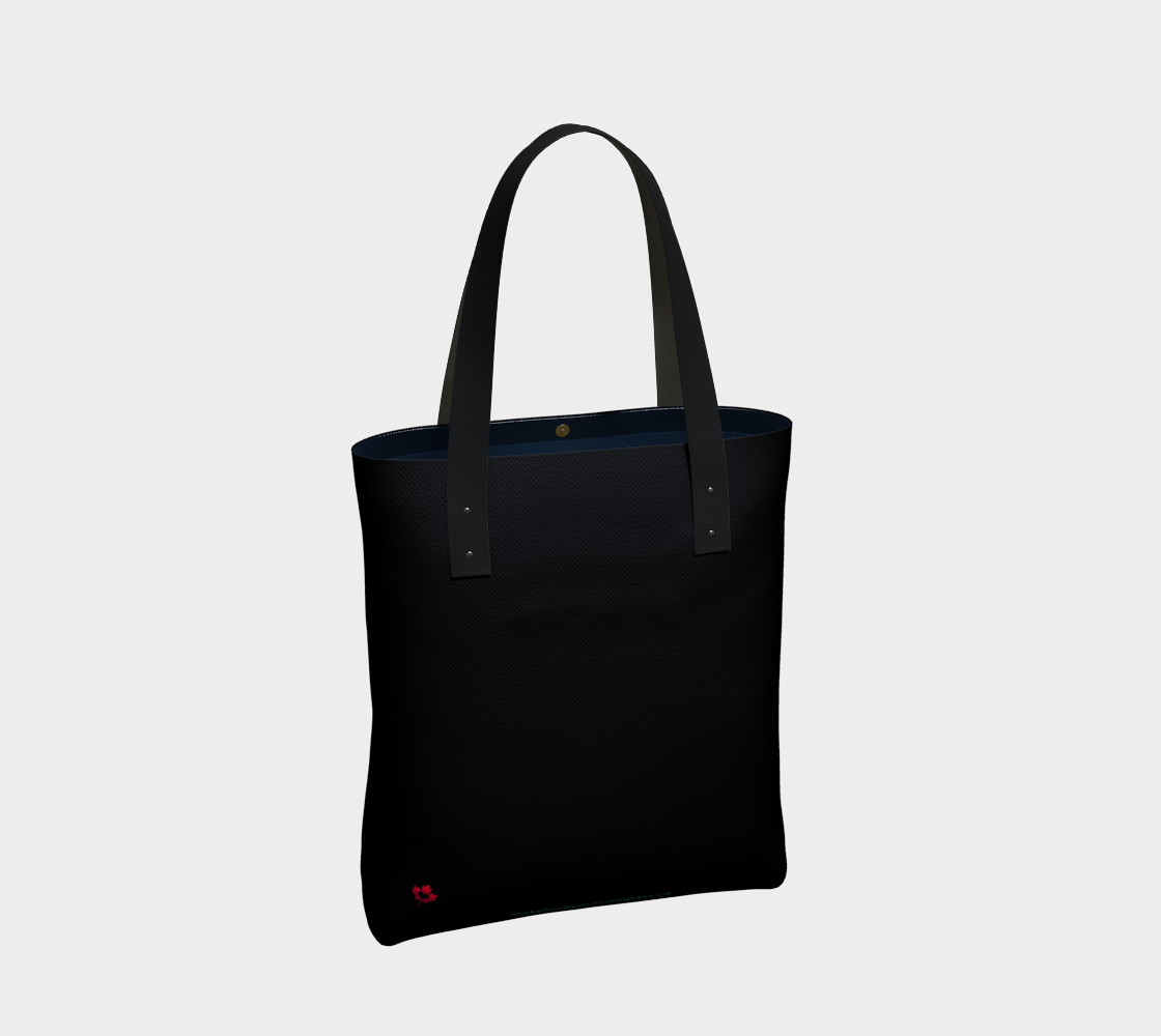 A black canvas tote bag with black shoulder straps and a small red logo near the bottom left corner, shown against a light gray background.