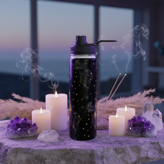 Black water bottle with purple cap on a table with candles and crystals